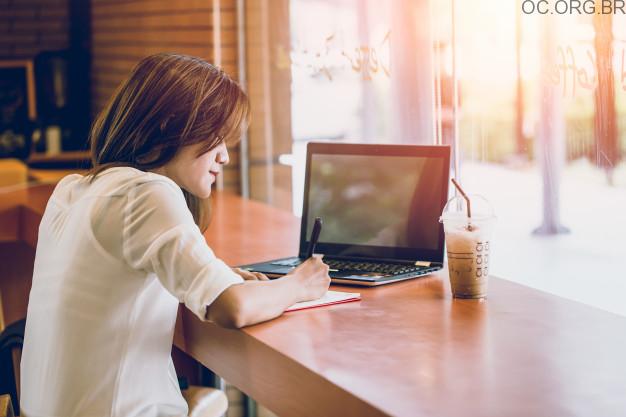 garota com copo fazendo anotações